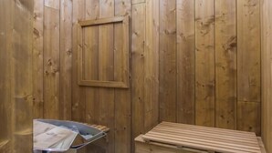 Sauna, jossa on puuseinät ja penkki.