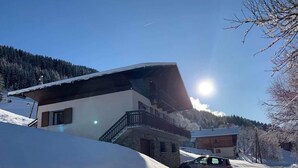 A modern two-story chalet with a balcony, surrounded by snow-covered mountains and a clear sky. - LE Boujou - Hauteluce-les-saisies (HAUTELUCE LES SAISIES)