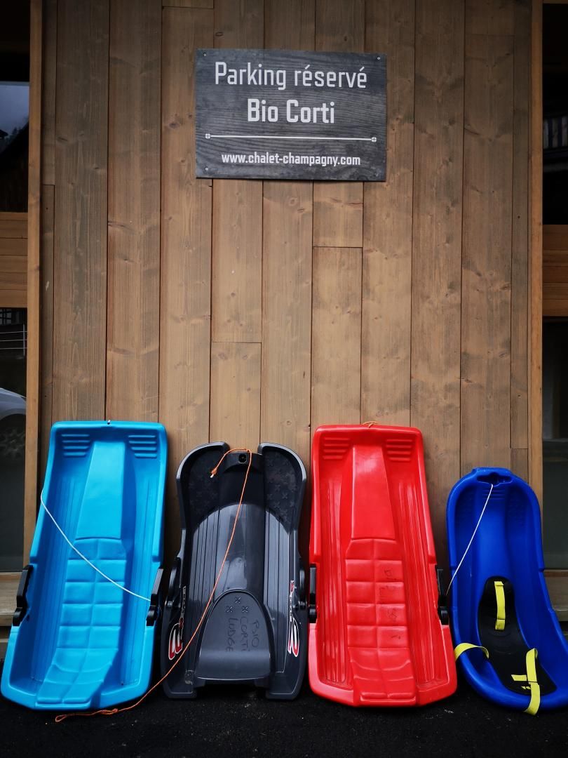 Een houten wand met een bord waarop aangegeven staat gereserveerd parkeren voor Bio Corti en een website-adres.