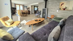 Ein stilvolles Wohnzimmer mit einer Couch, Sesseln, einem Couchtisch und einem Kamin.