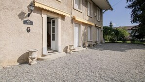 Een gebouw met twee verdiepingen, een grindpad en een bordje met de tekst 'The Old House'.