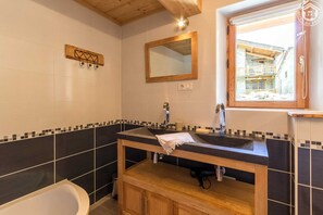 Banheira, secador de cabelo, toalhas de banho 