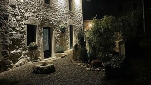 A stone building with a gravel driveway and a well-lit entrance. - Chez LA Philo - Nances (NANCES)