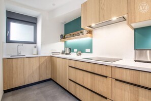 A modern kitchen with wooden cabinets, a stainless steel sink, and a built-in range hood.