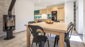 A modern kitchen with wooden cabinets, a central island, and a built-in oven. - Chez LA Philo - Nances (NANCES)