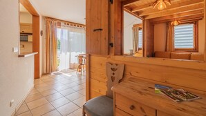 Un interior de madera con zona de comedor, un banco y una mesa con revistas.