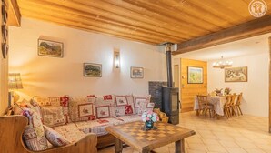 Ein gemütliches Wohnzimmer mit einer Holzsofa, einem Schachtisch und einem Kamin.