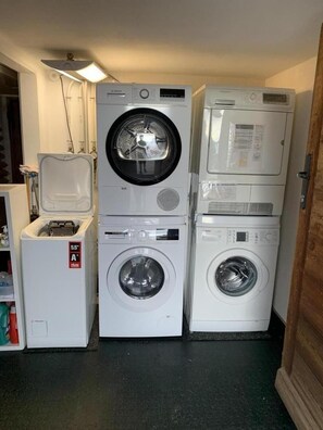 A laundry room with stacked washing machines and a dryer.