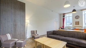 A modern living room with a sofa, chairs, a wooden table, and a lamp. - DE Saint Jean Baptiste (BEAUFORT ARECHES)