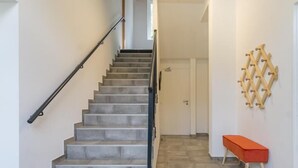 A staircase with a handrail, a bench, and a wall-mounted rack. - DE Saint Jean Baptiste (BEAUFORT ARECHES)