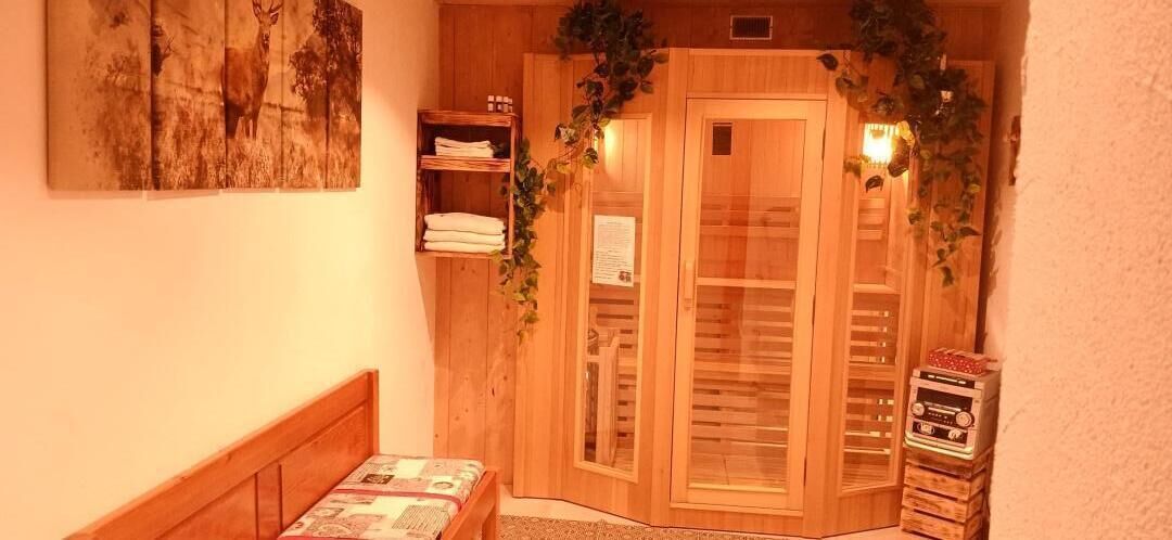 Ein Zimmer mit einem hölzernen Bett, einem Holzschrank und einem Regal mit gefalteten Handtüchern.