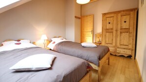 A bedroom with two beds, wooden wardrobe, and a skylight. - Chez Marie - Albiez Montrond (ALBIEZ MONTROND)