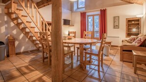 A wooden staircase leading to a dining area with a round table and chairs. - LA Pastorale - LE Genepi (VAL CENIS)