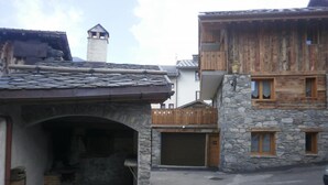 A rustic building with a stone facade, wooden balconies, and a garage. - LES Cabris - Meribel-les-allues (MERIBEL LES ALLUES)