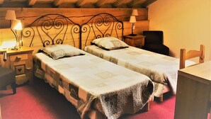 A cozy attic bedroom with two single beds, wooden headboard, and a skylight. - LES Cabris - Meribel-les-allues (MERIBEL LES ALLUES)