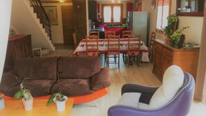 A cozy living room with a brown sofa, a purple chair, and a dining area with a table set for four. - LES Cabris - Meribel-les-allues (MERIBEL LES ALLUES)