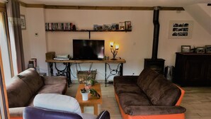 A living room with a sofa set, a television, a fireplace, and a bookshelf. - LES Cabris - Meribel-les-allues (MERIBEL LES ALLUES)