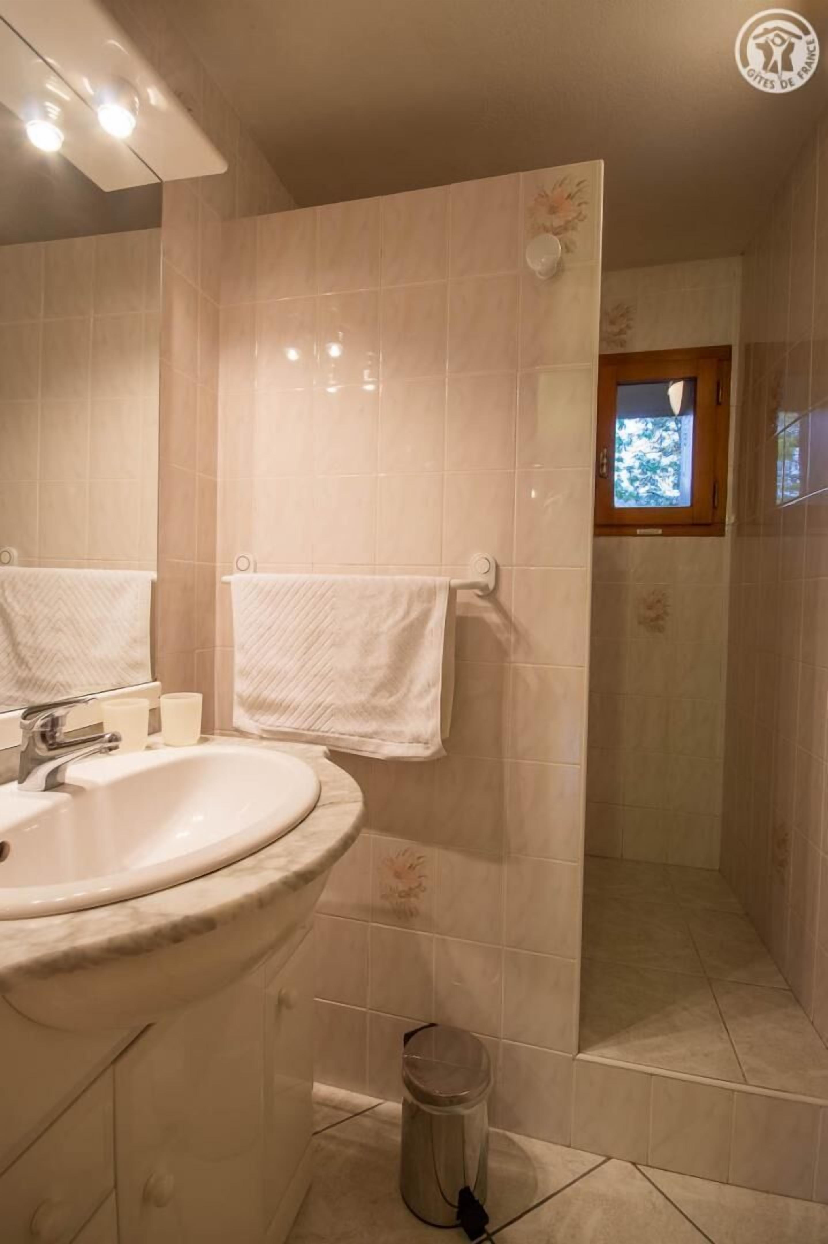 A bathroom with a sink, mirror, and towel rack.