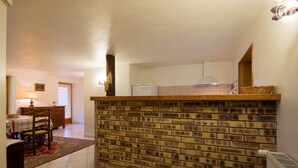 Eine Küche mit Backsteinwand, Holztisch und Heizkörper.