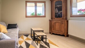 A living room with a sofa, a small table, a cabinet, and a radiator.