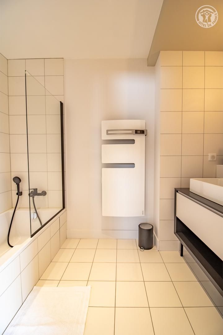 A modern bathroom with a shower, a toilet, and a sink.