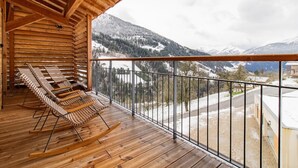Ein Holzbalkon mit Blick auf schneebedeckte Berge.