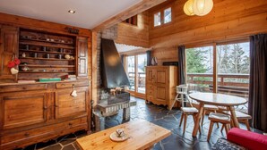 A wooden interior with a fireplace, stone flooring, and a dining area with a table and chairs. - LES Comognes - LA Rosiere-montvalezan (LA ROSIERE MONTVALEZAN)