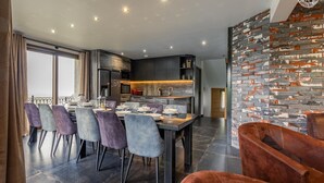 A modern dining area with a long table set for six, surrounded by purple chairs. - Hislianie - LES Belleville (LES BELLEVILLE)
