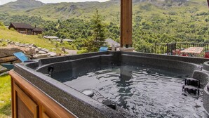 A hot tub with a wooden deck and a view of a mountainous landscape. - Hislianie - LES Belleville (LES BELLEVILLE)