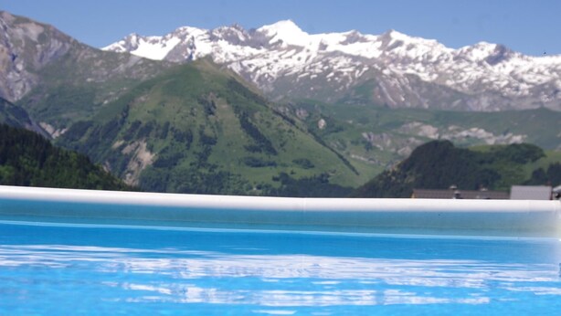Una piscina con montañas al fondo.