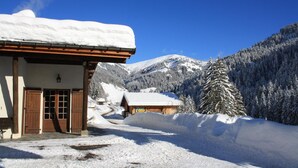 A snow-covered mountain lodge with a wooden facade, a clear sky, and a snowy landscape. - LA Flambee - LA Giettaz (LA GIETTAZ)