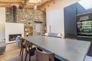 A modern kitchen with a large island, stone wall, and built-in Bosch appliances.