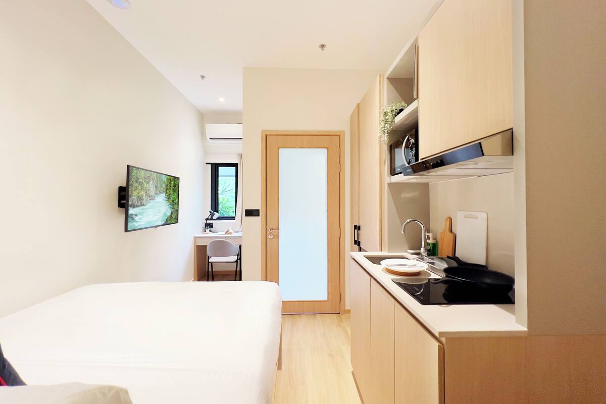 Une chambre d’hôtel moderne équipée d’un lit, d’un bureau et d’une kitchenette.