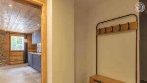 A modern kitchen with dark cabinets, a wooden countertop, and a window with curtains.