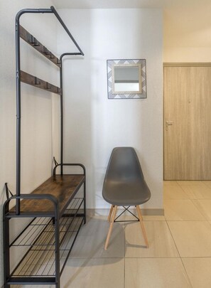 Ein kleines Zimmer mit Etagenbett, Stuhl, Spiegel und Tür.