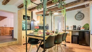 Una cucina moderna con mobili in legno, un tavolo da pranzo con sedie e una sveglia appesa al muro.