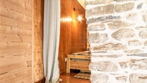 Un interno in legno con una parete in pietra e una panca di legno.