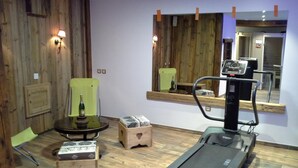A room with a treadmill, a massage chair, and a wooden wall. - Chalet LES Ancolies - Valloire (VALLOIRE)