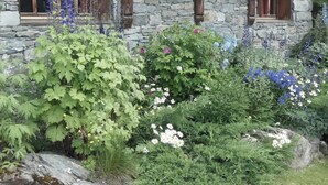 A stone building with a garden in front.