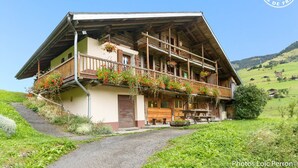 En traditionell chalet med ett sluttande tak, träbalkonger och blomlådor.