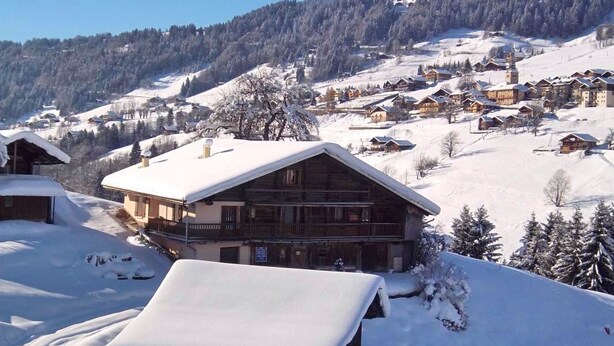 A snow-covered mountain village with wooden houses and a prominent lodge with a balcony. - LE Glopet - Hauteluce-les-saisies (HAUTELUCE-LES-SAISIES)