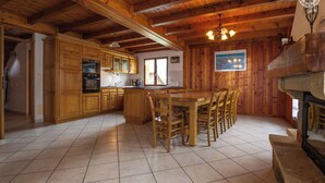 Ein Holzblockhaus-Interieur mit Küche, Essbereich und Kamin.