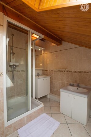 A bathroom with a glass shower enclosure, a sink, and a vanity. - LA Grange Villard - Albiez Montrond (ALBIEZ MONTROND)