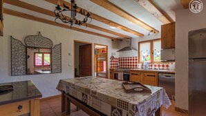 Una cocina con vigas de madera, estufa y refrigerador.