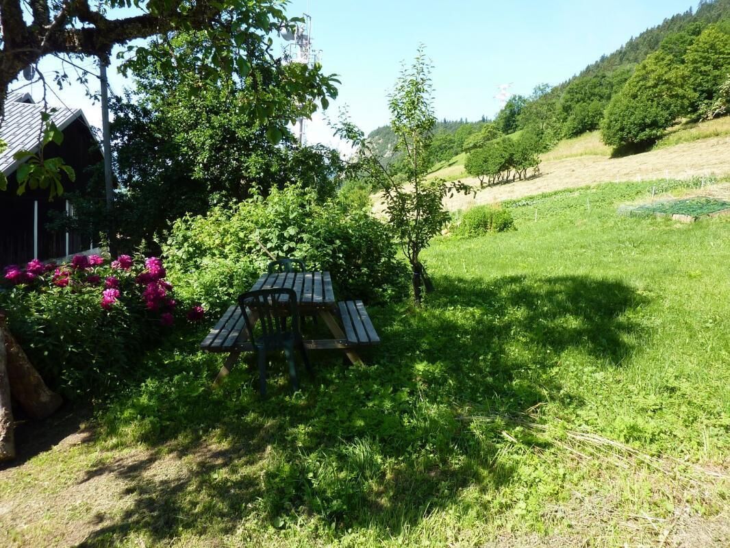 Een picknicktafel in een grasveld, met bomen en een gebouw op de achtergrond.