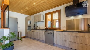 Una cocina moderna con armarios de madera, electrodomésticos de acero inoxidable y lavavajillas.