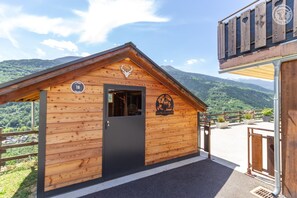 A wooden cabin with a door, a window, and a logo on the wall.