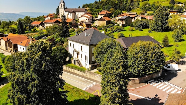 A village with a prominent church, residential houses, and a main road.