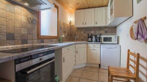 A compact kitchen with a built-in oven, microwave, and coffee maker.