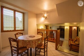 Enjoy meals in this inviting dining area with a round table for four, surrounded by comfortable chairs and a beautiful garden view.
